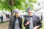 Two visitors of a former Innovation Day are wearing virtual reality glasses